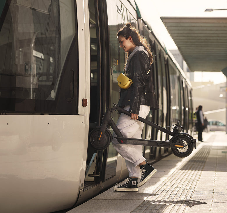 Woman boarding a train. Adult electric scooter. Xiaomi. Mi M365 electric scooter. Available from Electric Travels https://electrictravels.co.uk/